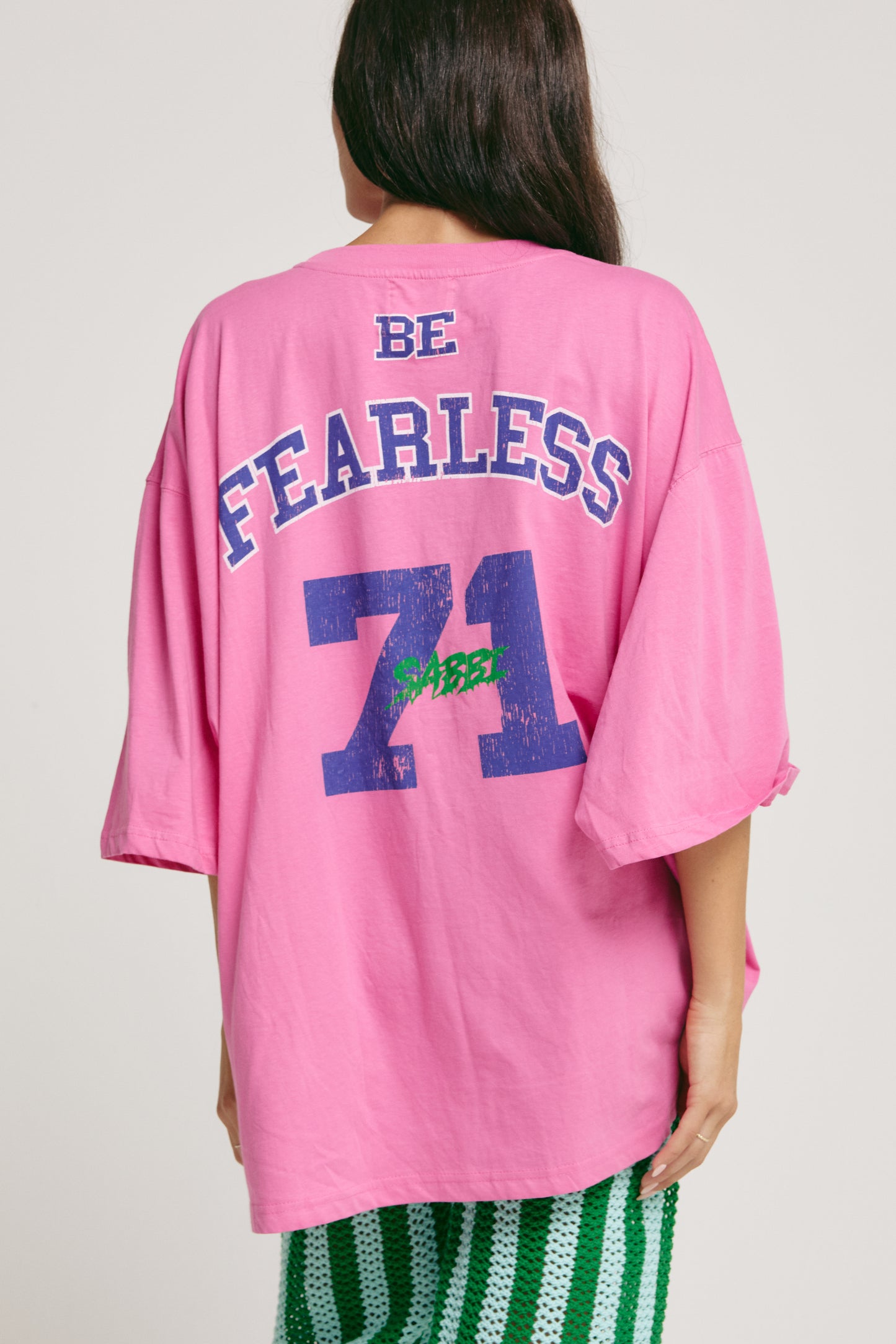 Big fit. Bigger dreams. All vibes.
The Very Oversized Dream Big Beaded Tee from Sabbi is your go-to for effortless, bold style. Made for dreamers, doers, and anyone who loves to make a statement without saying a word, this tee brings major energy in a seriously comfy, relaxed silhouette.
Sporting a varsity-inspired “Dream Big” front print with eye-catching beaded detailing, plus a fearless “Be Fearless 71” statement on the back, it’s all about vintage sports vibes with that signature Sabbi twist. Whether