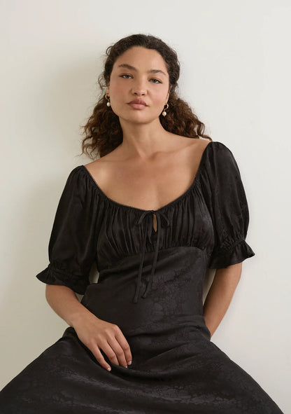 Enid Midi Dress - Auguste

The Enid Midi Dress in Black is a refined new silhouette with an effortlessly feminine feel. Featuring a soft scoop neckline with delicate trim, a gently gathered bodice, and a flattering bias-cut shape, it skims the body beautifully before falling into an elegant draped hem. Crafted in a luxurious textured floral jacquard fabrication.

Our studio model Carol is 176cm / 5'9" and wears a Size S.