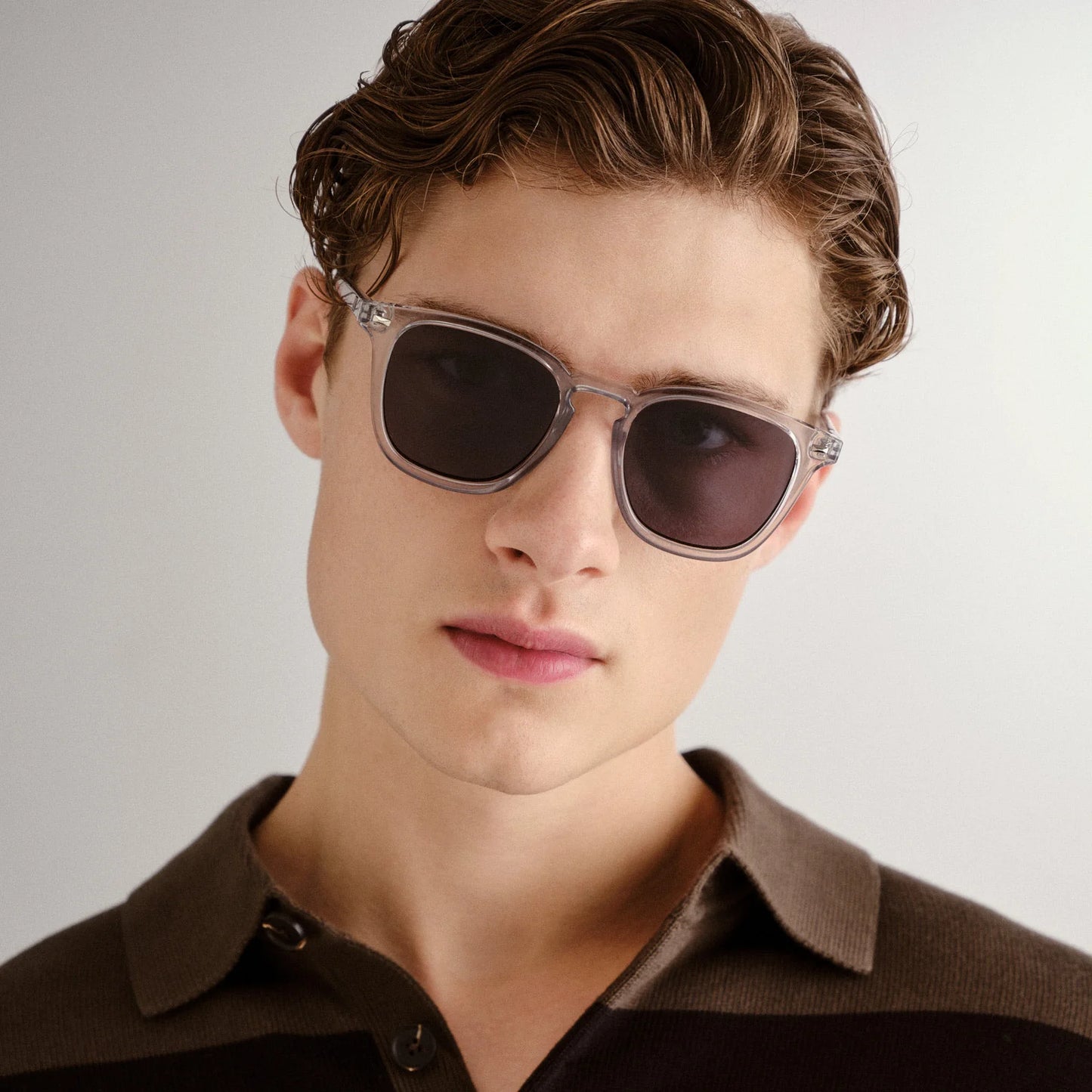 NO BIGGIE is a modern take on a fifties rectangular shape, offering the sharpest look of the season. Featuring classic rivet detailing, it combines bold style with timeless appeal.

• Finished in a crystal grey frame with dark lenses.
• Made using BPA free polymer plastic which is lightweight, durable and impact resistant.
• Fitted with shatterproof and scratch resistant polycarbonate lenses