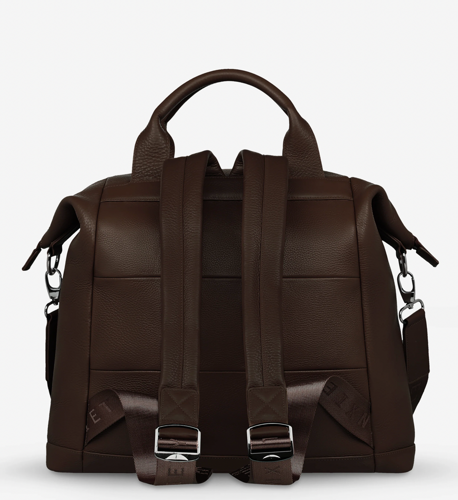 Comes In waves Cocoa - Status Anxiety 

Made to double as an oversized backpack or baby bag. The 'Comes In Waves' bag has enough space and pockets to keep everything in just the right place, and can be clipped onto the handle of a pram with our 'Up All Night' baby bag straps (sold separately).

Soft shrunken pebble leather
Front zipper pocket
Internal zipper pocket, and open pouch pockets
Internal bottle pockets
Internal key clip
Zipper close
Padded shoulder straps
Fits a 16 inch MacBook