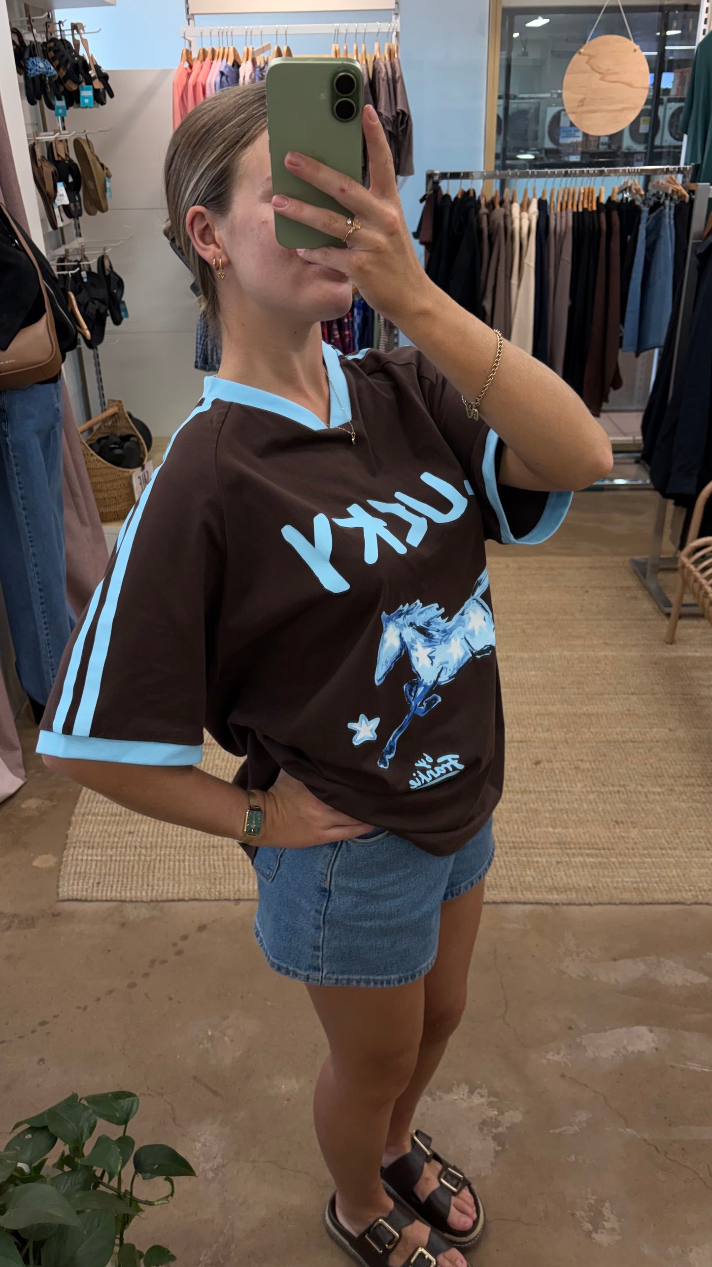 By Frankie Lucky Horse Oversized T-Shirt Chocolate & Blue is a statement everyday tee featuring a bold lucky horse graphic across the bust and a relaxed boxy oversized fit. Designed with a small V-neckline and contrast ribbed edging on the cuffs and neckline, this tee adds a sporty vintage-inspired touch while keeping your look comfortable and effortless.