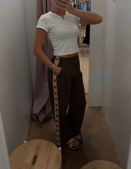 Star Racer Pants - By Frankie 

Details
Make a statement with the Star Racer Pants in chocolate brown and cream stripe. The high-waisted silhouette features an elasticated waistband and front tie detail for a flattering fit. Practical side pockets and a straight leg cut complete the look.

Product Details:

High waisted
Elasticated waist band
Front tie detail
Side pockets
Straight leg fit
Race stripe detail on side seams