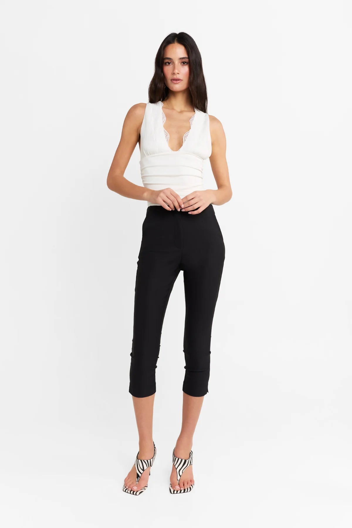 Introducing the Camille Top by Madison The Label, an elegant twist to an everyday basic. This fitted top features a deep V neckline, contrast lace trim through neckline, and under bust seam detail with soft gathers. It is fully lined with a fitted silhouette, gathered waist detail, and it's crafted in a soft stretch fabrication. Pair with the Paloma Pants to complete the look.

Hope is wearing a size extra small. She is 180cm (5'11) tall, has an 76cm bust, 58cm waist and 89cm hips.