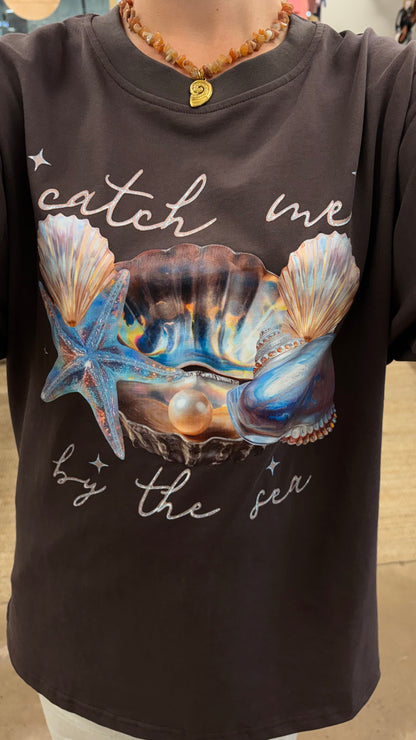 Catch Me By The Sea Tee - Paper Heart 

The Catch Me By Sea Tee features an oversized fit and a circle neck for comfort and ease of wear. Its chocolate brown fabric is complemented by a detailed sea shell chrome print, adding a distinctive visual element suitable for casual and relaxed settings.