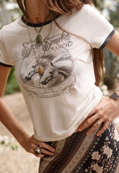 Silver Spring Tee Spell


The Silver Spring Tee in Vintage Cream channels effortless vintage attitude with an iconic Spell edge. Inspired by classic biker tees, this timeless silhouette brings a rebellious spirit to everyday dressing with a softly lived-in feel.

Crafted from 100% organic cotton in a slub cotton fabrication, it offers a breathable, textured feel with an authentic vintage character. The shrunken tee fit creates a flattering, more fitted silhouette, while short sleeves finished with rib cuffs