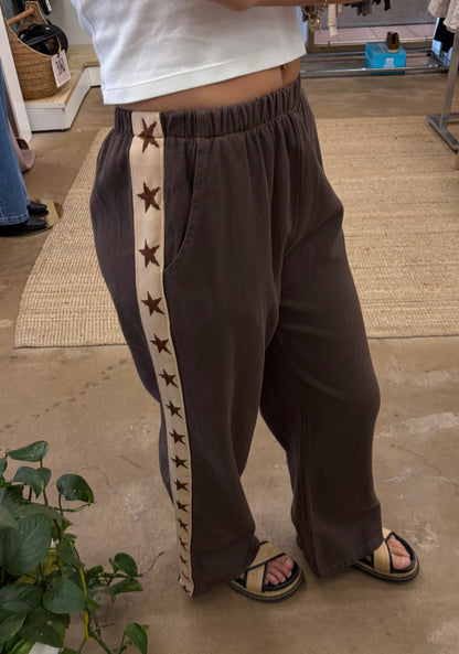Star Racer Pants - By Frankie 

Details
Make a statement with the Star Racer Pants in chocolate brown and cream stripe. The high-waisted silhouette features an elasticated waistband and front tie detail for a flattering fit. Practical side pockets and a straight leg cut complete the look.

Product Details:

High waisted
Elasticated waist band
Front tie detail
Side pockets
Straight leg fit
Race stripe detail on side seams
