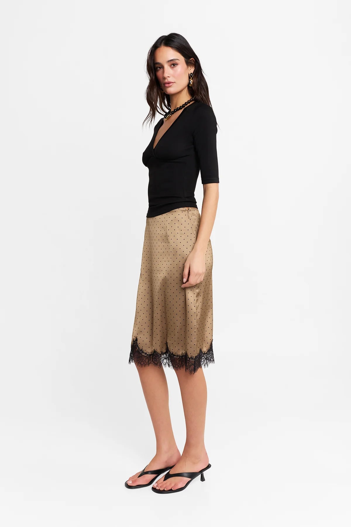 The Lucia Skirt by Madison The Label is an elegant mid rise design. This fitted midi skirt is mid rise and features a straight column silhouette. It is crafted in a polka dot printed satin fabrication with a contrast lace panel at hem. The hem has a scalloped edge adding a touch of uniqueness while maintaining it's feminine look with the lace detail. Pair with the Samira Top for the complete look.

Hope is wearing a size XS (AU6). She is 180cm (5'11), has a 58cm bust, 58cm waist, and 89cm hips.