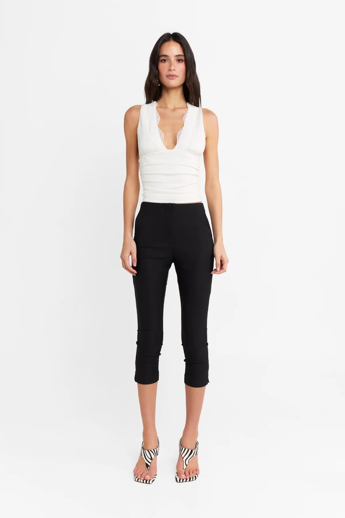Introducing the Camille Top by Madison The Label, an elegant twist to an everyday basic. This fitted top features a deep V neckline, contrast lace trim through neckline, and under bust seam detail with soft gathers. It is fully lined with a fitted silhouette, gathered waist detail, and it's crafted in a soft stretch fabrication. Pair with the Paloma Pants to complete the look.

Hope is wearing a size extra small. She is 180cm (5'11) tall, has an 76cm bust, 58cm waist and 89cm hips.