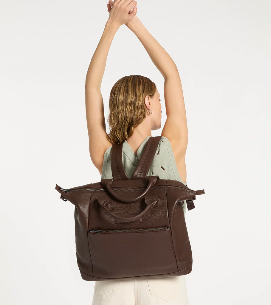 Comes In waves Cocoa - Status Anxiety 

Made to double as an oversized backpack or baby bag. The 'Comes In Waves' bag has enough space and pockets to keep everything in just the right place, and can be clipped onto the handle of a pram with our 'Up All Night' baby bag straps (sold separately).

Soft shrunken pebble leather
Front zipper pocket
Internal zipper pocket, and open pouch pockets
Internal bottle pockets
Internal key clip
Zipper close
Padded shoulder straps
Fits a 16 inch MacBook