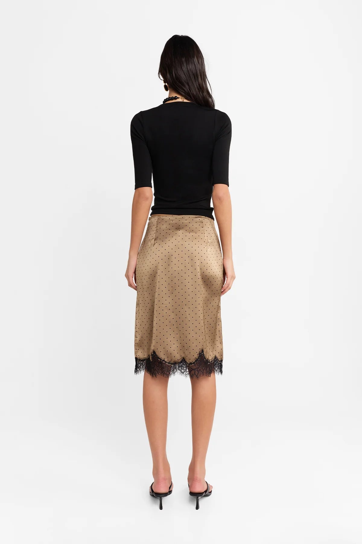The Lucia Skirt by Madison The Label is an elegant mid rise design. This fitted midi skirt is mid rise and features a straight column silhouette. It is crafted in a polka dot printed satin fabrication with a contrast lace panel at hem. The hem has a scalloped edge adding a touch of uniqueness while maintaining it's feminine look with the lace detail. Pair with the Samira Top for the complete look.

Hope is wearing a size XS (AU6). She is 180cm (5'11), has a 58cm bust, 58cm waist, and 89cm hips.