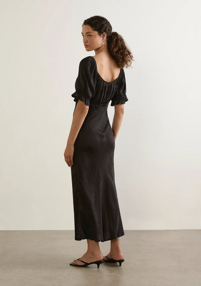 Enid Midi Dress - Auguste

The Enid Midi Dress in Black is a refined new silhouette with an effortlessly feminine feel. Featuring a soft scoop neckline with delicate trim, a gently gathered bodice, and a flattering bias-cut shape, it skims the body beautifully before falling into an elegant draped hem. Crafted in a luxurious textured floral jacquard fabrication.

Our studio model Carol is 176cm / 5'9" and wears a Size S.
