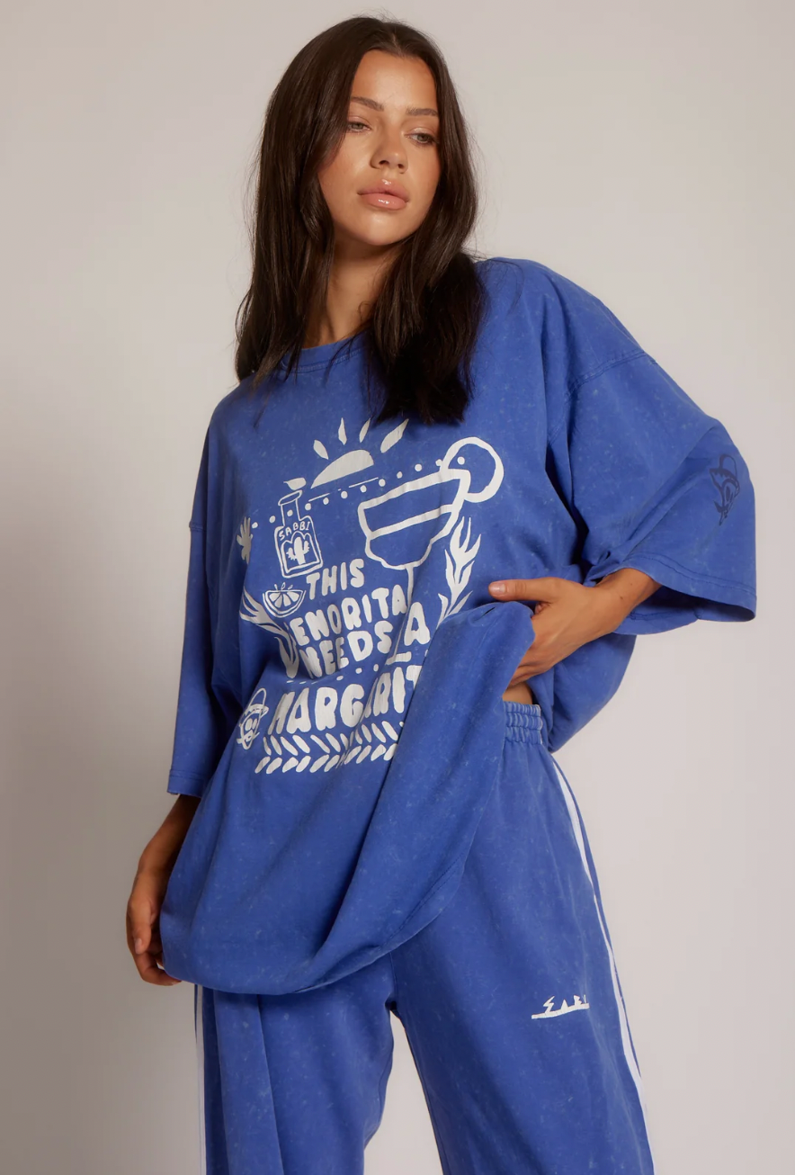 The Very Oversized Margie Tee - Royal - SABBI

The Very Oversized Margie Tee is the one you throw on when you’re absolutely not doing boring. ??

Think: sun-soaked mornings, salty hair and that first icy margarita. Cut in Sabbi’s very oversized fit, it drapes off the body with that perfectly slouchy, borrowed-from-your-bestie energy. She’s crafted from our signature soft, washed cotton that feels like you’ve already loved her for years.

The front features our hand-drawn “This Señorita Needs A Margarita”