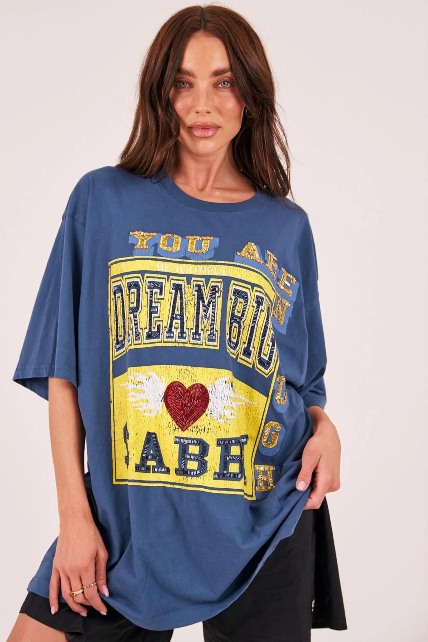 Go big, dream louder. This tee’s not here to play small.

Big vibes, bold energy. The Very Oversized Dream Big Beaded Tee by Sabbi is made for those who dream loud, live freely, and never wait for permission. With our signature very oversized silhouette, it’s all about effortless comfort, relaxed proportions, and graphics that stand out.

The varsity-inspired Dream Big Sabbi front print pops with beaded detailing, while the striking Be Fearless 71 statement on the back channels vintage sports energy with a 