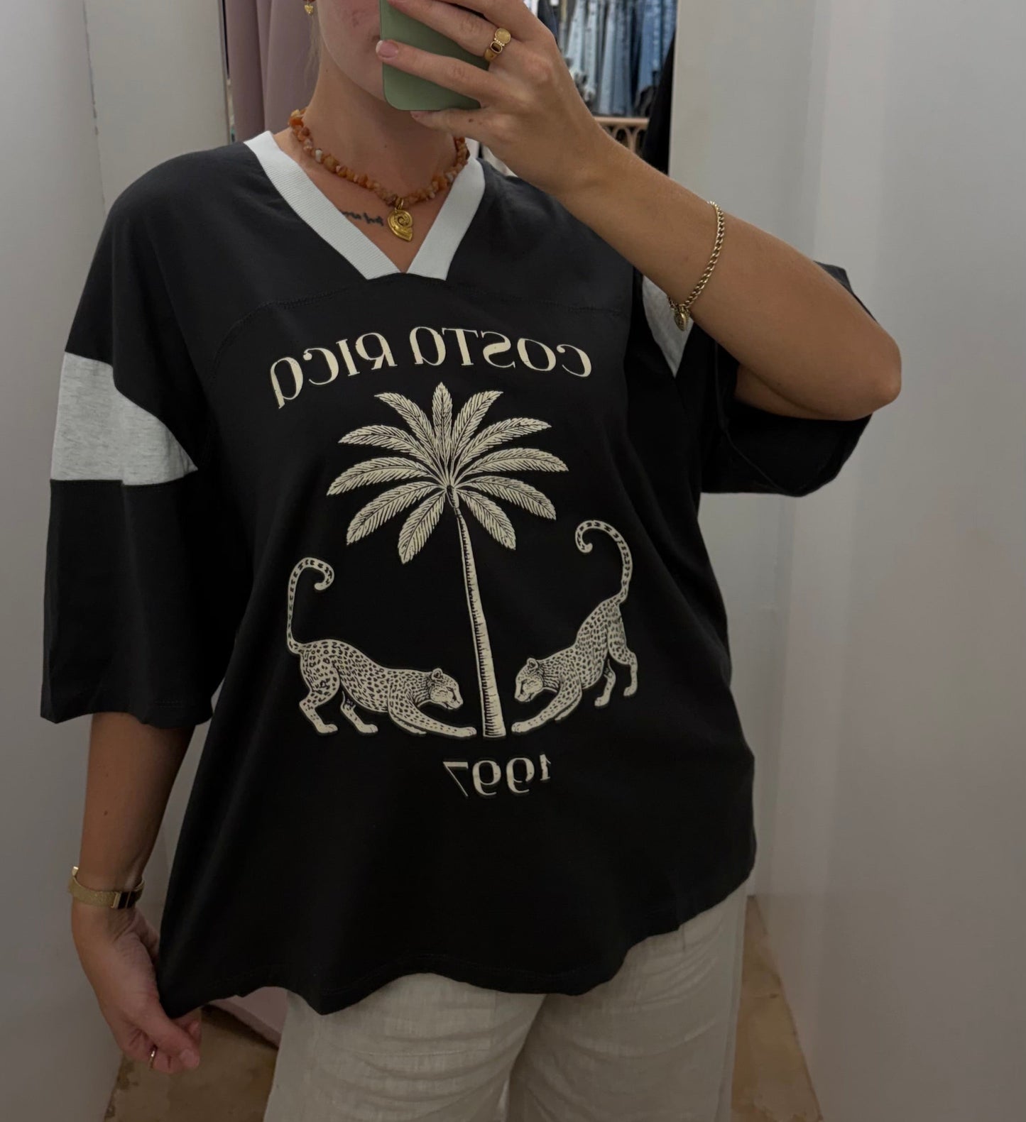 Costa Rica Tee - PaperHeart 

The Costa Rica Tee features a structured, oversized fit with a V-neckline, providing comfort and breathability. Its black-grey colorway highlights a detailed graphic print of a leopard and palm tree, reflecting Costa Rica's natural environment. The design balances style with casual versatility.