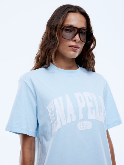 Bold lines. Casual rhythm.

Step up your everyday style with the Ena Pelly Collegiate Tee, where laid-back comfort meets sporty, modern edge. Made from a soft recycled-cotton blend, this tee delivers easy vibes and effortless wear. Perfect paired with jeans, shorts, or your weekend joggers.
