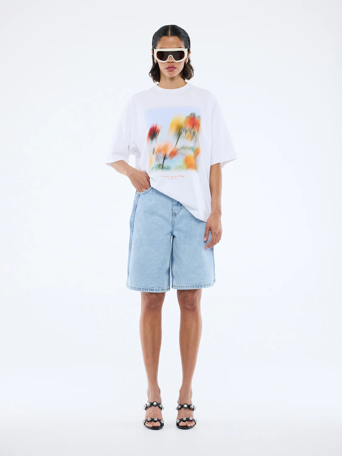 Turn heads in effortless style. The Blurred Daisy Frame Tee is your new go-to for laid-back vibes with a modern twist.

Meet the Ena Pelly Blurred Daisy Frame Tee, where comfort meets statement-making style. Cut in an oversized silhouette with relaxed drop shoulders, this tee brings that effortlessly cool, boxy fit you’ll reach for again and again. Its bold, in-house graphic print adds a contemporary edge, while the classic crew neckline keeps things timeless and wearable.