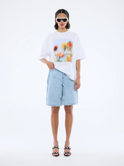 Turn heads in effortless style. The Blurred Daisy Frame Tee is your new go-to for laid-back vibes with a modern twist.

Meet the Ena Pelly Blurred Daisy Frame Tee, where comfort meets statement-making style. Cut in an oversized silhouette with relaxed drop shoulders, this tee brings that effortlessly cool, boxy fit you’ll reach for again and again. Its bold, in-house graphic print adds a contemporary edge, while the classic crew neckline keeps things timeless and wearable.