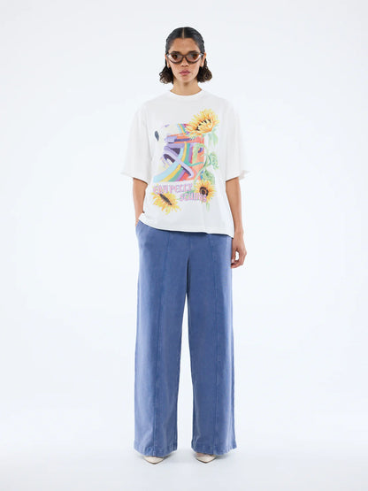 Radiant charm meets effortless style. 

The Sunflower Warp Tee by Ena Pelly is your new everyday mood-lifter. Made from soft cotton jersey, this tee offers an oversized, relaxed fit for ultimate comfort and easy layering. Its vibrant, retro-inspired warp graphic paired with bold sunflower illustrations brings nostalgic energy with a modern twist. The classic crew neckline and lived-in feel make it a go-to for weekend adventures, casual days, or layering under jackets for extra flair.