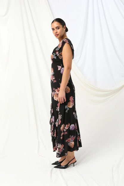 Introducing the Marilyn Maxi Dress by KACHEL - a total showstopper with a fun, flirty twist.
With a deep V-neckline, soft ruffled sleeves, and a ruffled split, this dress is all about movement, style, and feel-good vibes. Splashed in colours and a florals, it strikes the perfect balance between elegance and fun. Whether you're heading to a summer party, a garden wedding, or just want to feel amazing, this beauty is guaranteed to turn heads and brighten your day.

Maxi length
Ruffled short sleeves
V-neckline