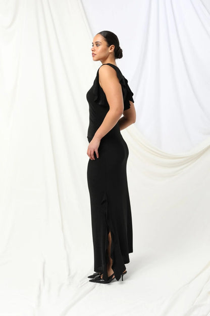 Lydia Dress - Kachel 
Super chic and effortlessly classy, the Lydia Maxi Dress by Kachel is a must-have addition to your wardrobe.

This stunning dress is all about fun, flair, and feeling fabulous. Featuring a graceful boat neckline, soft ruffled cap sleeves, and a floaty ruffled split hem, it's made to move with you. The sleek black hue adds an elegant touch, making it perfect for parties or whenever you're in the mood to dress up and stand out.