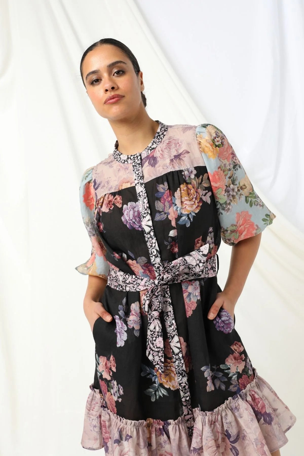 Sasha Mini Dress - Kachel 
Presenting the Sasha Mini Dress by Kachel - cute and fresh and made to flatter.

Featuring short puff sleeves and a high neckline, this playful mini is finished with a classic button-up front and a waist tie to cinch the waist just right. The frilled hem adds a dash of whimsy, while the tailored silhouette keeps it polished and put-together. Whether you're off to brunch or heading out for the evening, this dress strikes the perfect balance between fun and elegance.