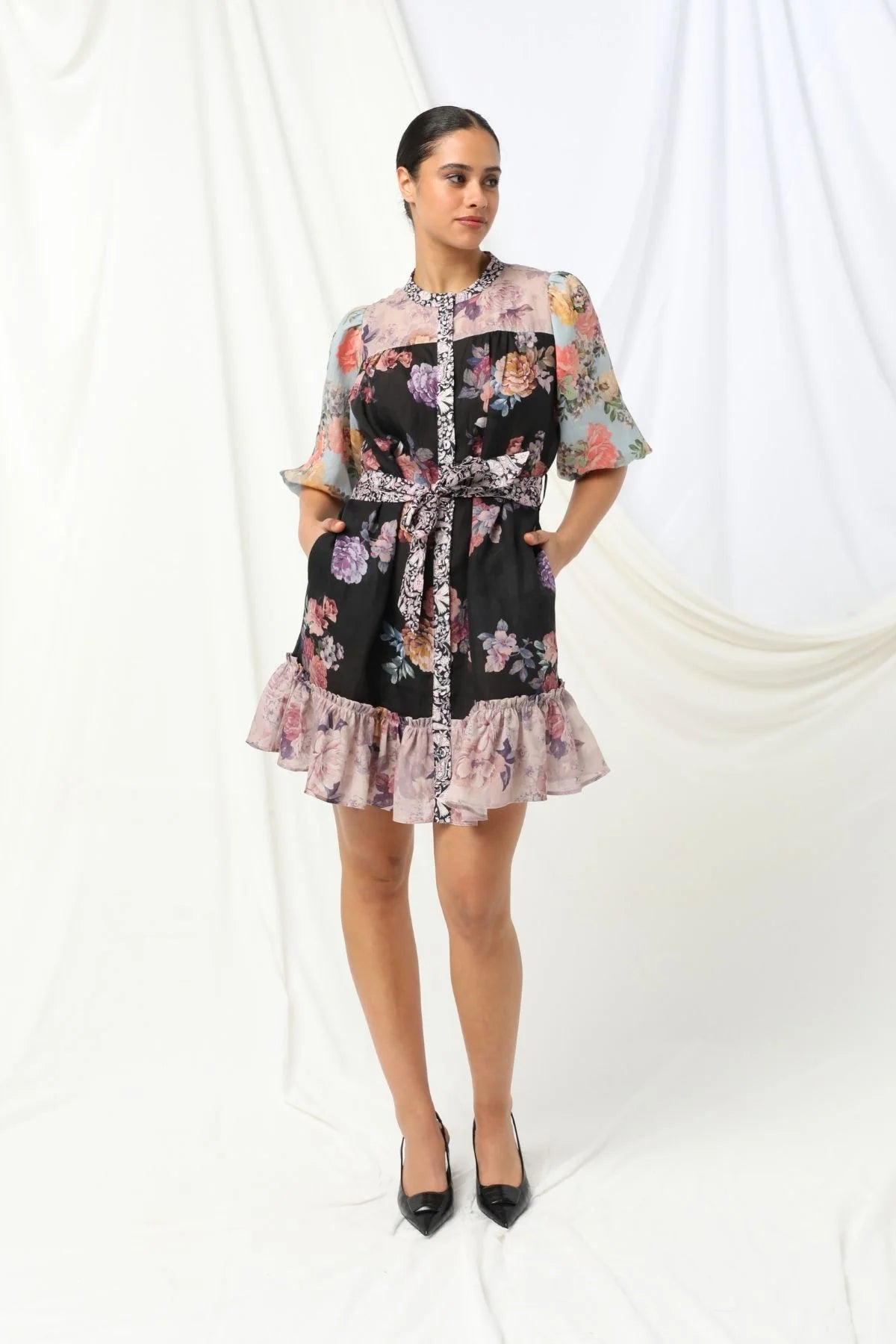Sasha Mini Dress - Kachel 
Presenting the Sasha Mini Dress by Kachel - cute and fresh and made to flatter.

Featuring short puff sleeves and a high neckline, this playful mini is finished with a classic button-up front and a waist tie to cinch the waist just right. The frilled hem adds a dash of whimsy, while the tailored silhouette keeps it polished and put-together. Whether you're off to brunch or heading out for the evening, this dress strikes the perfect balance between fun and elegance.