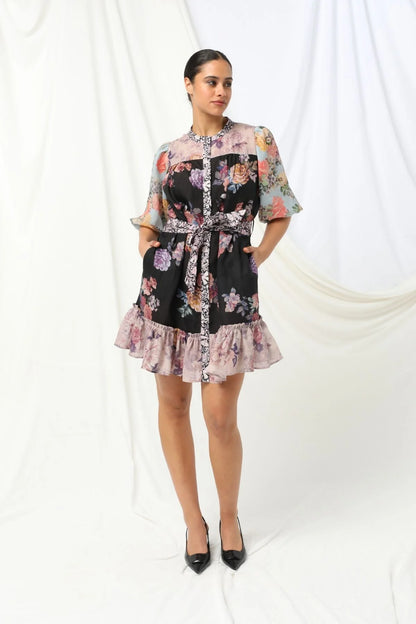 Sasha Mini Dress - Kachel 
Presenting the Sasha Mini Dress by Kachel - cute and fresh and made to flatter.

Featuring short puff sleeves and a high neckline, this playful mini is finished with a classic button-up front and a waist tie to cinch the waist just right. The frilled hem adds a dash of whimsy, while the tailored silhouette keeps it polished and put-together. Whether you're off to brunch or heading out for the evening, this dress strikes the perfect balance between fun and elegance.