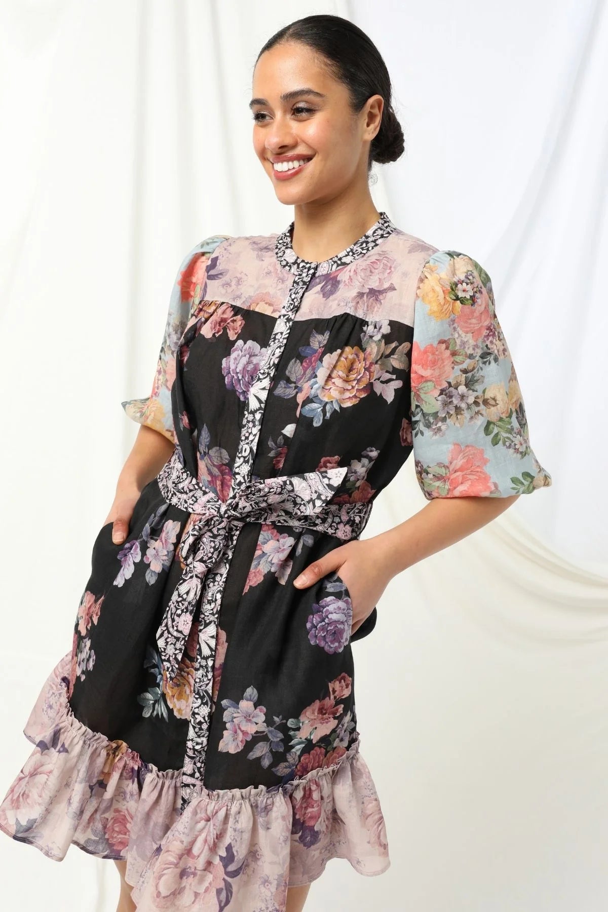 Sasha Mini Dress - Kachel 
Presenting the Sasha Mini Dress by Kachel - cute and fresh and made to flatter.

Featuring short puff sleeves and a high neckline, this playful mini is finished with a classic button-up front and a waist tie to cinch the waist just right. The frilled hem adds a dash of whimsy, while the tailored silhouette keeps it polished and put-together. Whether you're off to brunch or heading out for the evening, this dress strikes the perfect balance between fun and elegance.