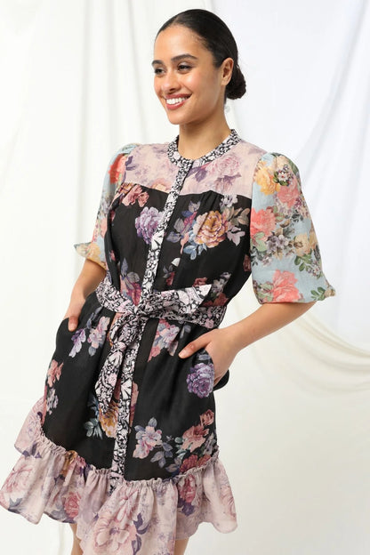 Sasha Mini Dress - Kachel 
Presenting the Sasha Mini Dress by Kachel - cute and fresh and made to flatter.

Featuring short puff sleeves and a high neckline, this playful mini is finished with a classic button-up front and a waist tie to cinch the waist just right. The frilled hem adds a dash of whimsy, while the tailored silhouette keeps it polished and put-together. Whether you're off to brunch or heading out for the evening, this dress strikes the perfect balance between fun and elegance.