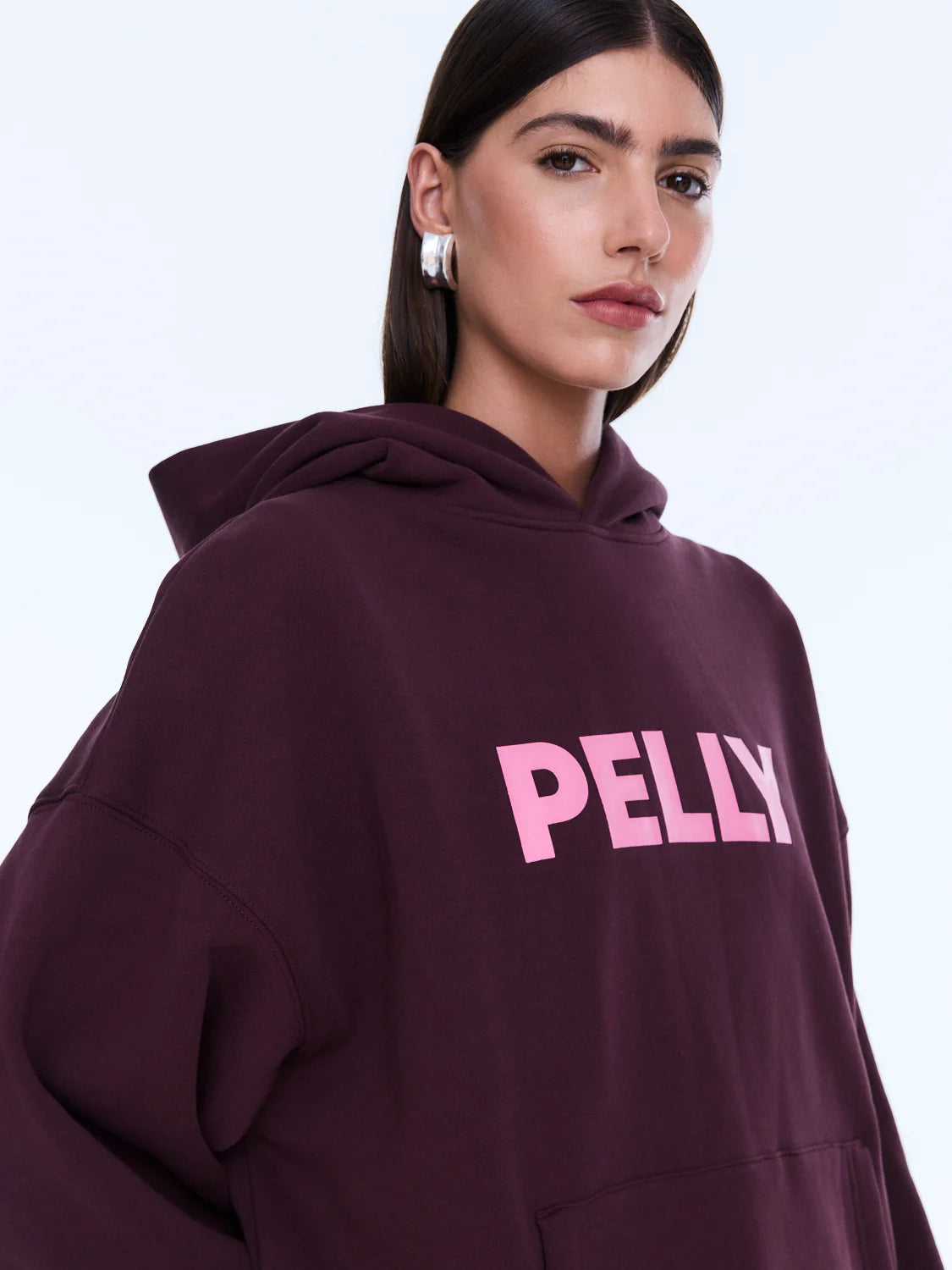 Street Energy. Everyday Ease. 
The Cassie Oversized Hoodie is cut from soft brushed cotton blend fleece in deep cherry red with an oversized silhouette and relaxed dropped shoulders. Finished with bold pop pink Pelly graphics across the chest for a playful statement grounded in everyday comfort.

Cotton rich brushed fleece hoodie
Oversized fit with drop shoulder
Self lined hood
In house graphic design
Rib cuffs and hem band
Model is 176cm and wears size 8