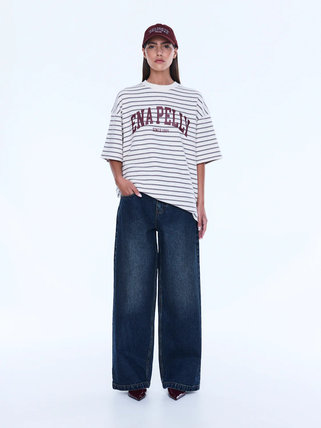 Maeve Relaxed Tee - Ena Pelly 
Everyday Cool. Effortless Edge.
The Maeve Relaxed Tee is cut in an oversized silhouette from soft cotton blend jersey with dropped shoulders and a classic crew neckline. Finished with collegiate-inspired artwork and a contrast Ena Pelly chest print that delivers bold everyday street energy.

Oversized graphic tee
Size down if you prefer a less oversized look
In house graphic artwork
Short sleeves with crew neck and drop shoulder
Model is 176cm and wears size 8
