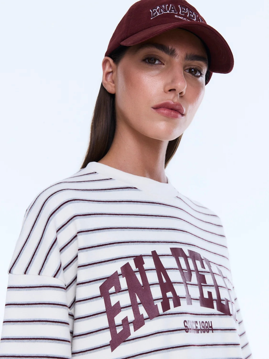 Maeve Relaxed Tee - Ena Pelly 
Everyday Cool. Effortless Edge.
The Maeve Relaxed Tee is cut in an oversized silhouette from soft cotton blend jersey with dropped shoulders and a classic crew neckline. Finished with collegiate-inspired artwork and a contrast Ena Pelly chest print that delivers bold everyday street energy.

Oversized graphic tee
Size down if you prefer a less oversized look
In house graphic artwork
Short sleeves with crew neck and drop shoulder
Model is 176cm and wears size 8
