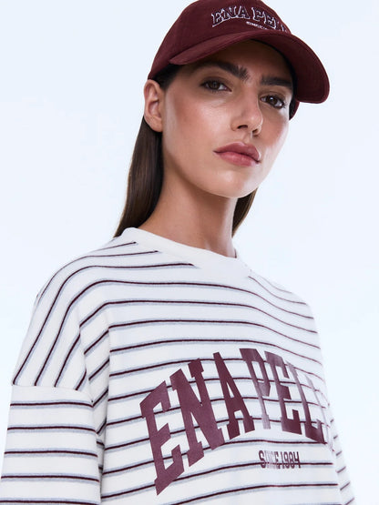 Maeve Relaxed Tee - Ena Pelly 
Everyday Cool. Effortless Edge.
The Maeve Relaxed Tee is cut in an oversized silhouette from soft cotton blend jersey with dropped shoulders and a classic crew neckline. Finished with collegiate-inspired artwork and a contrast Ena Pelly chest print that delivers bold everyday street energy.

Oversized graphic tee
Size down if you prefer a less oversized look
In house graphic artwork
Short sleeves with crew neck and drop shoulder
Model is 176cm and wears size 8
