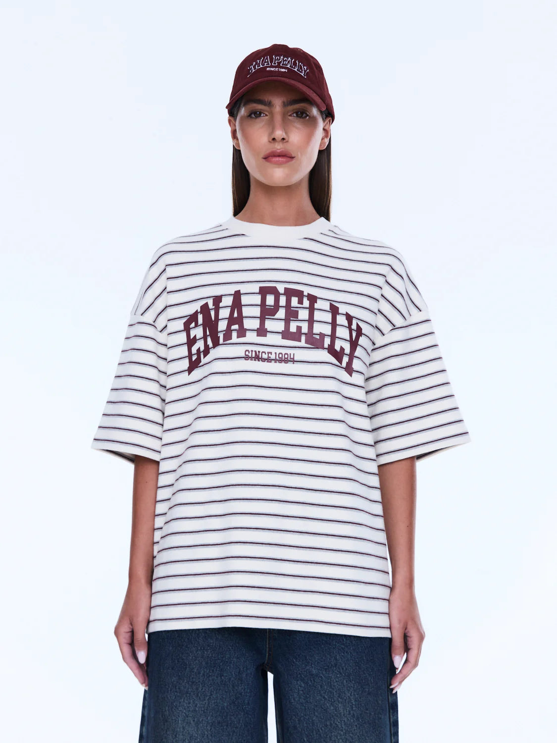 Maeve Relaxed Tee - Ena Pelly 
Everyday Cool. Effortless Edge.
The Maeve Relaxed Tee is cut in an oversized silhouette from soft cotton blend jersey with dropped shoulders and a classic crew neckline. Finished with collegiate-inspired artwork and a contrast Ena Pelly chest print that delivers bold everyday street energy.

Oversized graphic tee
Size down if you prefer a less oversized look
In house graphic artwork
Short sleeves with crew neck and drop shoulder
Model is 176cm and wears size 8
