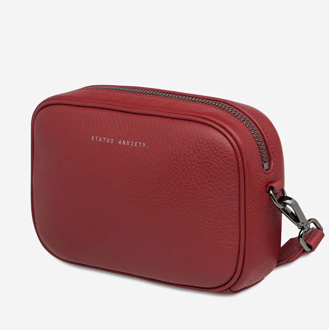 Plunder Bag With Dual Straps - Rouge - Status Anxiety 
Our best selling bag of all time now comes with two different straps for twice the versatility. Clip on the leather strap for dressier occasions, or the webbed strap for a more casual vibe. It's a no brainer.

Soft shrunken pebble leather
Comes with Leather Strap Thin & Web Strap Medium
Back slider pocket
Internal zipper pocket, and open pouch pockets
Zipper close
Custom Status Anxiety lining
Comes in a Status Anxiety branded drawstring bag
