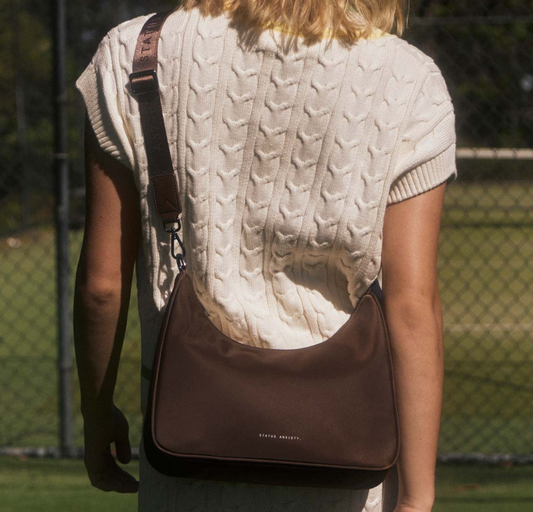 Fleur Recycled Bag - Truffle - Status Anxiety 

Versatile and deceptively roomy. 'Fleur' is made of premium reinforced recycled polyester to give it superior structure, and is finished with our branded zippers and tonal hardware. Comes equipped with dual interchangeable straps: a longer webbed strap for everyday crossbody use, and shorter shoulder strap for a dressier look. 
