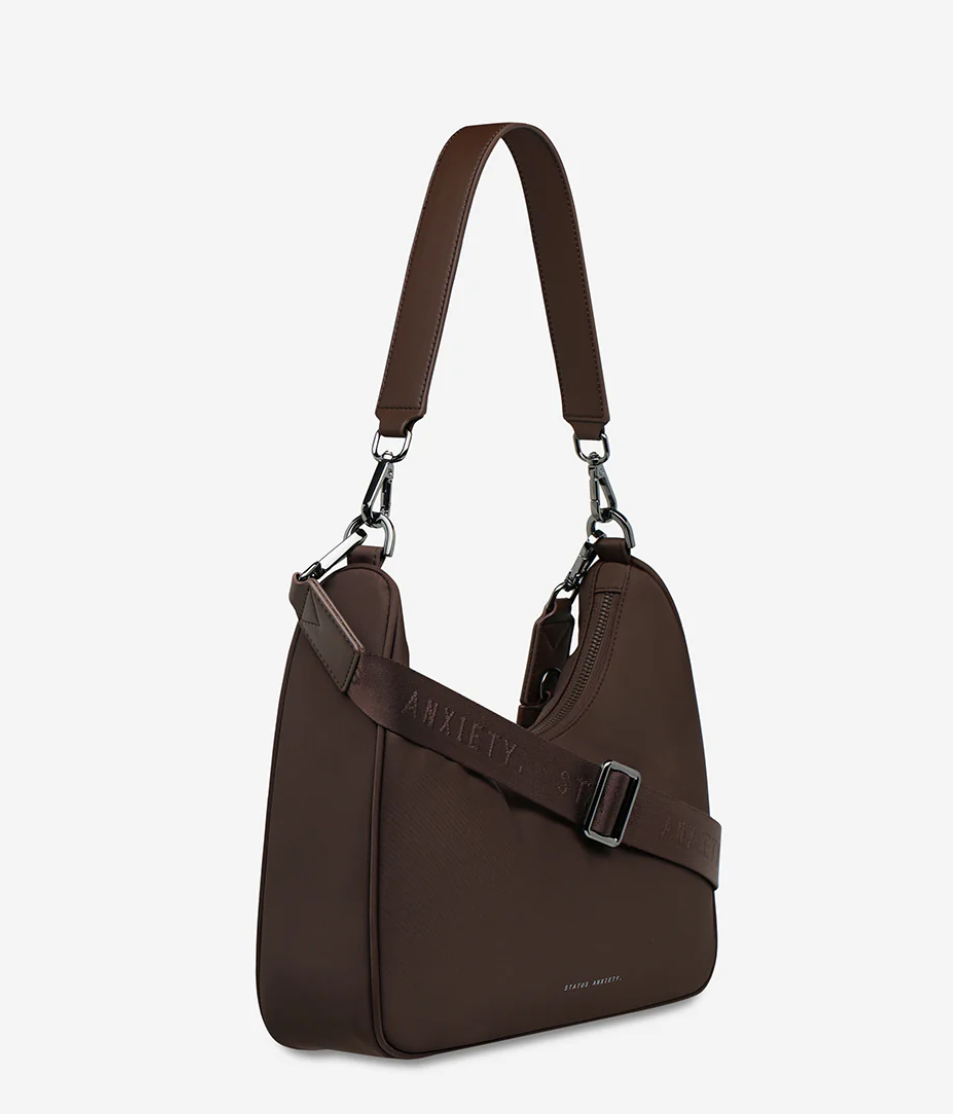 Fleur Recycled Bag - Truffle - Status Anxiety 

Versatile and deceptively roomy. 'Fleur' is made of premium reinforced recycled polyester to give it superior structure, and is finished with our branded zippers and tonal hardware. Comes equipped with dual interchangeable straps: a longer webbed strap for everyday crossbody use, and shorter shoulder strap for a dressier look. 
