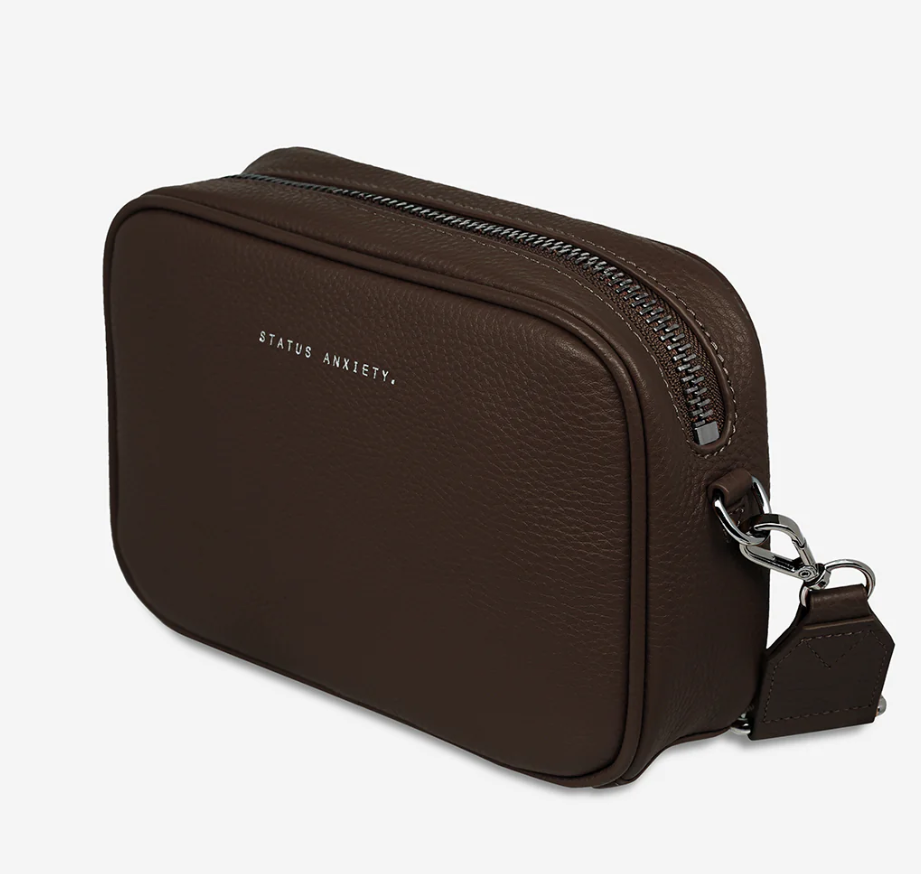 Plunder Bag With Dual Straps - Cocoa - Status Anxiety 

Our best selling bag of all time now comes with two different straps for twice the versatility. Clip on the leather strap for dressier occasions, or the webbed strap for a more casual vibe. It's a no brainer.

Soft shrunken pebble leather
Comes with Leather Strap Thin & Web Strap Medium
Back slider pocket
Internal zipper pocket, and open pouch pockets
Zipper close
Custom Status Anxiety lining
Comes in a Status Anxiety branded drawstring bag