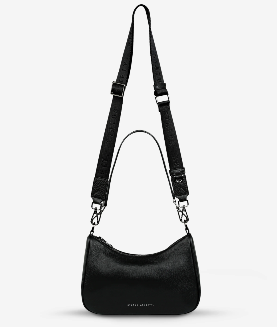 Look Both Ways Bag - Black - Status Anxiety 
The 'Look Both Ways' bag will keep people guessing with her dual personality straps. Use the shorter shoulder strap for a dressier on-the-go look or go the longer webbed strap option to give off a more casual 'I don't have plans today' vibe.

Soft shrunken pebble leather
Comes with leather shoulder strap and long webbed strap
Internal zipper pocket one side and 3 card slots on the other
Black custom Status Anxiety lining
20cm x 14cm x 7cm
Leather strap length 26c