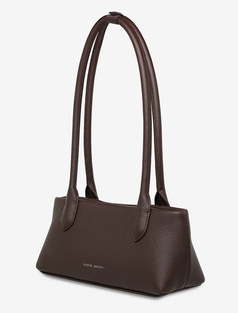 The Lost Bag - Cocoa - Status Anxiety 

Not everything that’s lost needs finding. 'The Lost' carries itself with quiet confidence – structured yet soft, refined yet unpretentious. Featuring an easy magnetic closure, internal lipstick and zipper pockets, and enough space for what really matters.

Soft shrunken pebble leather
Internal zipper pocket, and lipstick pocket
Long structured shoulder straps
Magnet closure
Custom Status Anxiety lining
Comes in a Status Anxiety branded drawstring bag
