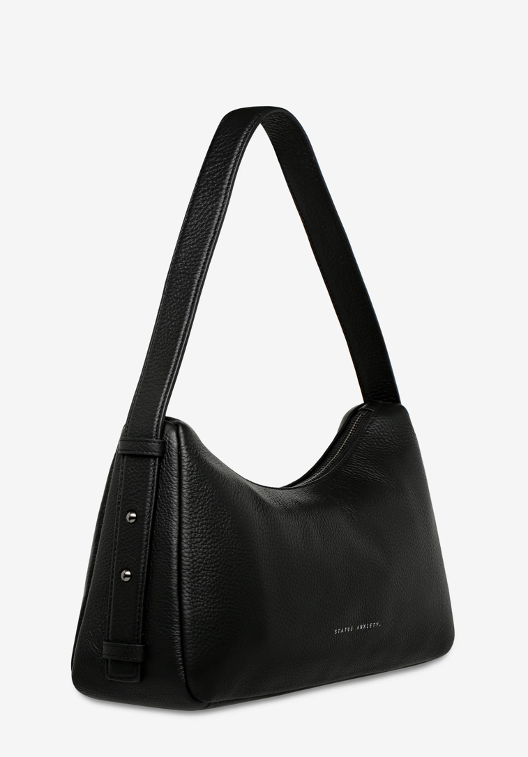 Hideout Bag - Black - Status Anxiety 

Understated in design and quietly capable in size, 'Hideout' keeps things simple with its soft, slouchy shape and attitude.

Soft shrunken pebble leather
Internal zipper pocket, lipstick pocket, and open pouch pocket
Zipper closure
Custom Status Anxiety lining
Comes in a Status Anxiety branded drawstring bag