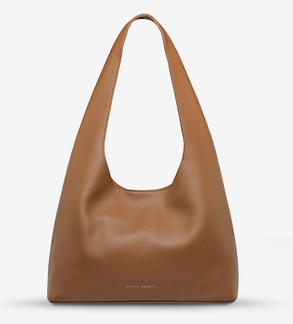 Solstice Bag - Camel - Status Anxiety 
Relaxed yet reliable, 'Solstice' is a slouchy tote that carries more than it lets on (including a 13-inch laptop). Soft, spacious, and closed with the snap of a magnet, 'Solstice' is unstructured and easygoing in all the right ways.

Soft shrunken pebble leather
Internal zipper pocket, lipstick pocket, and open pouch pocket
Fits a 13-inch laptop
Magnet closure
Custom Status Anxiety lining
Comes in a Status Anxiety branded drawstring bag