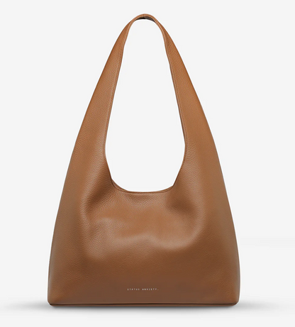 Solstice Bag - Camel - Status Anxiety 
Relaxed yet reliable, 'Solstice' is a slouchy tote that carries more than it lets on (including a 13-inch laptop). Soft, spacious, and closed with the snap of a magnet, 'Solstice' is unstructured and easygoing in all the right ways.

Soft shrunken pebble leather
Internal zipper pocket, lipstick pocket, and open pouch pocket
Fits a 13-inch laptop
Magnet closure
Custom Status Anxiety lining
Comes in a Status Anxiety branded drawstring bag