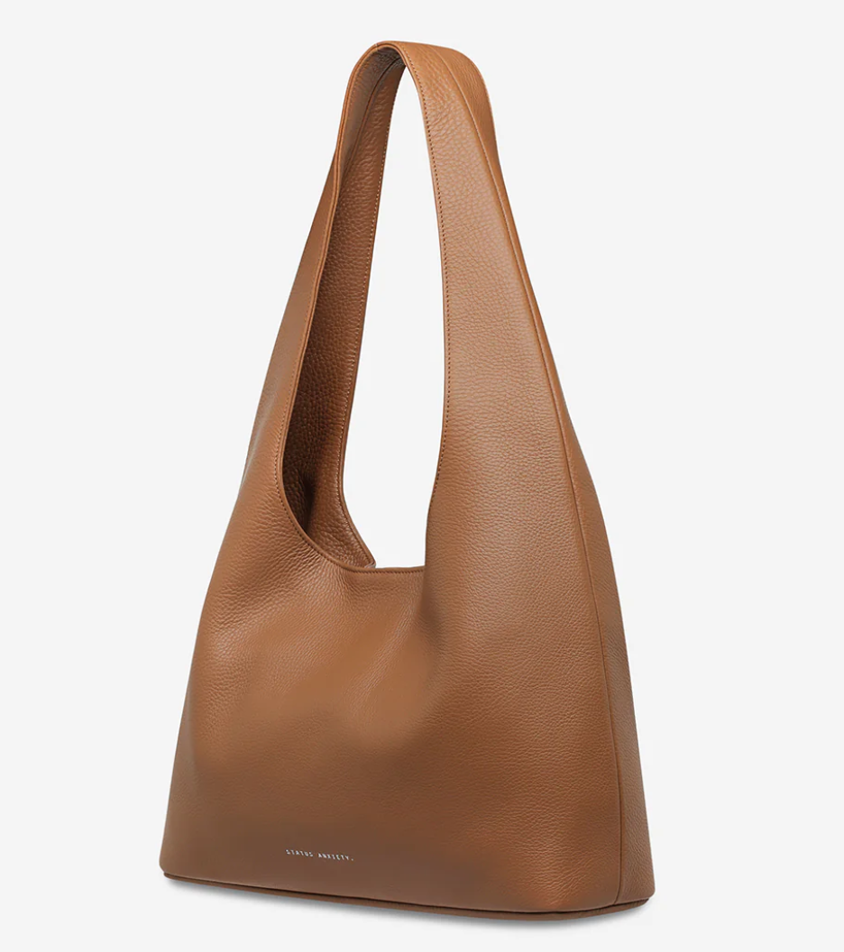 Solstice Bag - Camel - Status Anxiety 
Relaxed yet reliable, 'Solstice' is a slouchy tote that carries more than it lets on (including a 13-inch laptop). Soft, spacious, and closed with the snap of a magnet, 'Solstice' is unstructured and easygoing in all the right ways.

Soft shrunken pebble leather
Internal zipper pocket, lipstick pocket, and open pouch pocket
Fits a 13-inch laptop
Magnet closure
Custom Status Anxiety lining
Comes in a Status Anxiety branded drawstring bag