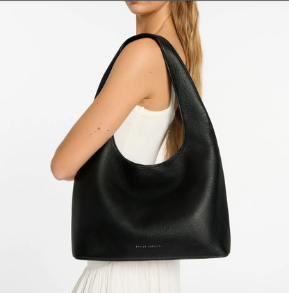 Solstice Bag - Black - Status Anxiety 

Relaxed yet reliable, 'Solstice' is a slouchy tote that carries more than it lets on (including a 13-inch laptop). Soft, spacious, and closed with the snap of a magnet, 'Solstice' is unstructured and easygoing in all the right ways.

Soft shrunken pebble leather
Internal zipper pocket, lipstick pocket, and open pouch pocket
Fits a 13-inch laptop
Magnet closure
Custom Status Anxiety lining
Comes in a Status Anxiety branded drawstring bag