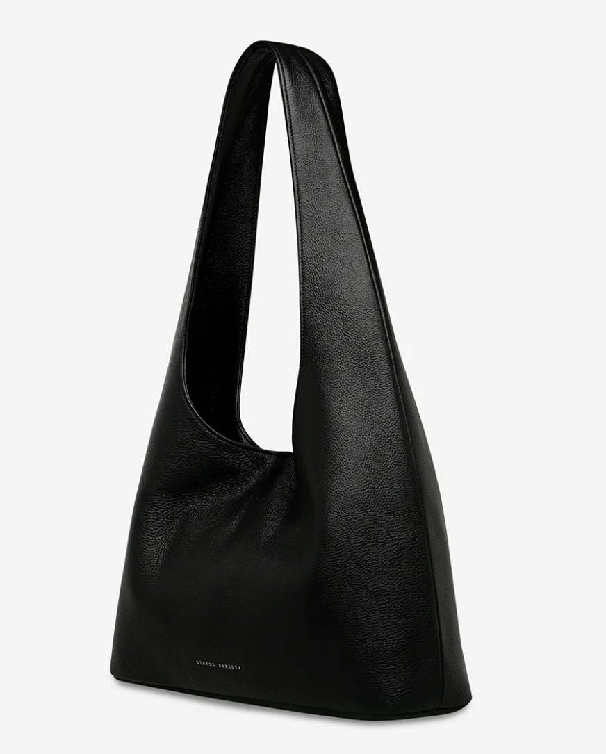 Solstice Bag - Black - Status Anxiety 

Relaxed yet reliable, 'Solstice' is a slouchy tote that carries more than it lets on (including a 13-inch laptop). Soft, spacious, and closed with the snap of a magnet, 'Solstice' is unstructured and easygoing in all the right ways.

Soft shrunken pebble leather
Internal zipper pocket, lipstick pocket, and open pouch pocket
Fits a 13-inch laptop
Magnet closure
Custom Status Anxiety lining
Comes in a Status Anxiety branded drawstring bag