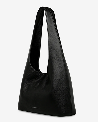 Solstice Bag - Black - Status Anxiety 

Relaxed yet reliable, 'Solstice' is a slouchy tote that carries more than it lets on (including a 13-inch laptop). Soft, spacious, and closed with the snap of a magnet, 'Solstice' is unstructured and easygoing in all the right ways.

Soft shrunken pebble leather
Internal zipper pocket, lipstick pocket, and open pouch pocket
Fits a 13-inch laptop
Magnet closure
Custom Status Anxiety lining
Comes in a Status Anxiety branded drawstring bag
