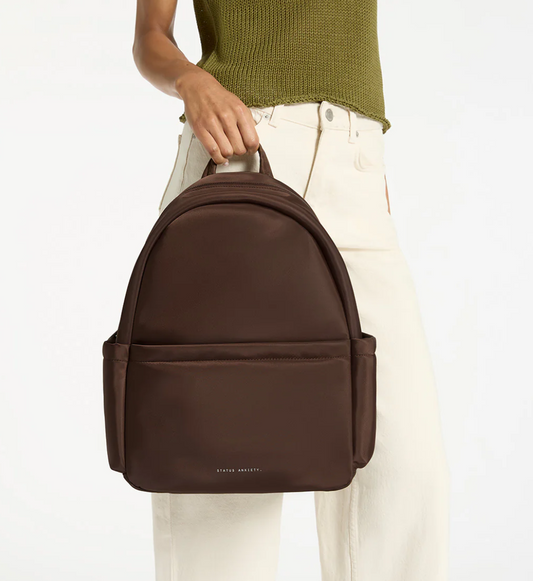 Frankie Recycled Bag - Truffle - Status Anxiety 

Tough, functional and lightweight – just what you've been looking for in a backpack (plus not to mention obvious good looks). Multiple exterior pockets keep everything within reach, while its lightweight build makes it ready for workdays, weekends, and everything between.

Premium reinforced recycled polyester (otherwise destined for landfill)
Back sleeve for sliding onto your suitcase
Dual external side pockets, and front zipper pocket
Internal open pockets