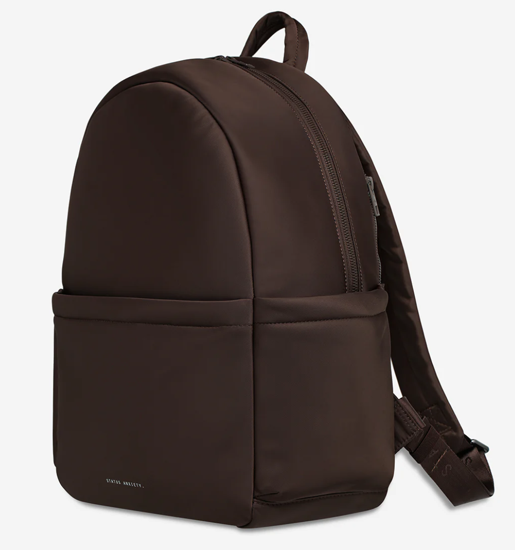 Frankie Recycled Bag - Truffle - Status Anxiety 

Tough, functional and lightweight – just what you've been looking for in a backpack (plus not to mention obvious good looks). Multiple exterior pockets keep everything within reach, while its lightweight build makes it ready for workdays, weekends, and everything between.

Premium reinforced recycled polyester (otherwise destined for landfill)
Back sleeve for sliding onto your suitcase
Dual external side pockets, and front zipper pocket
Internal open pockets