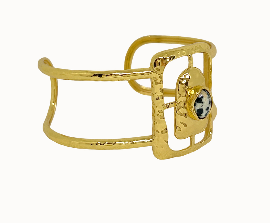 Astrid Gold Cuff - Mountain & Moon 

Description

Astrid commands attention without asking for it. A wide hammered gold cuff with an open rectangular frame at its centre, set with a Dalmatian Jasper stone - architectural, organic, and unmistakably considered.

A statement piece from the Odyssey collection - for the woman who adorns herself with meaning, not just habit.

Micron 18K gold & sterling silver plating 
to premium jewellery standards